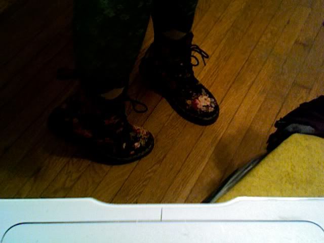 a pair of feet in flowered doc marten boots, standing on tiptoes